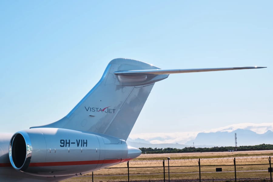 Tail and engine of a VistaJet aircraft against the mountains, Cape Town