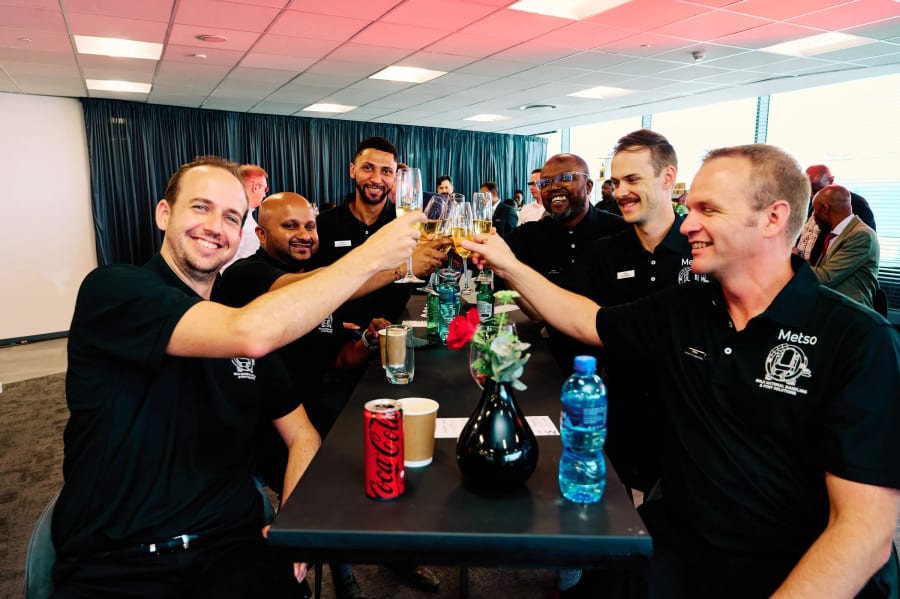 Colleagues raising a toast together around a table at a corporate office opening, Cape Town