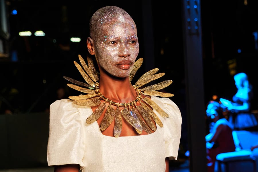 Model wearing a gold feather statement neckpiece on the Mineshift runway, Zeitz MOCAA, Cape Town