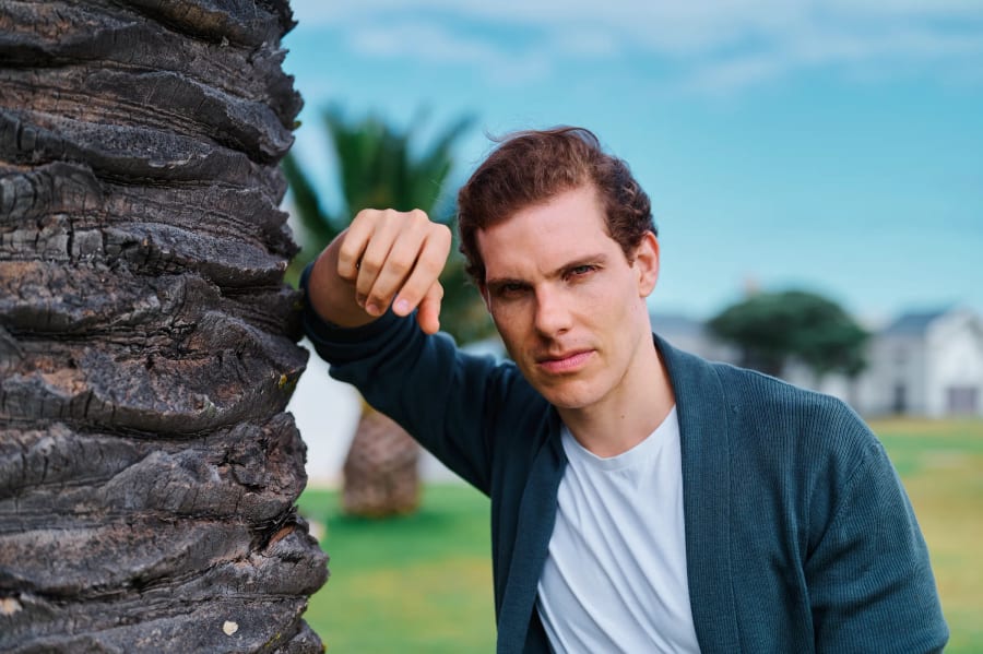Personal branding portrait leaning against a palm tree, Cape Town