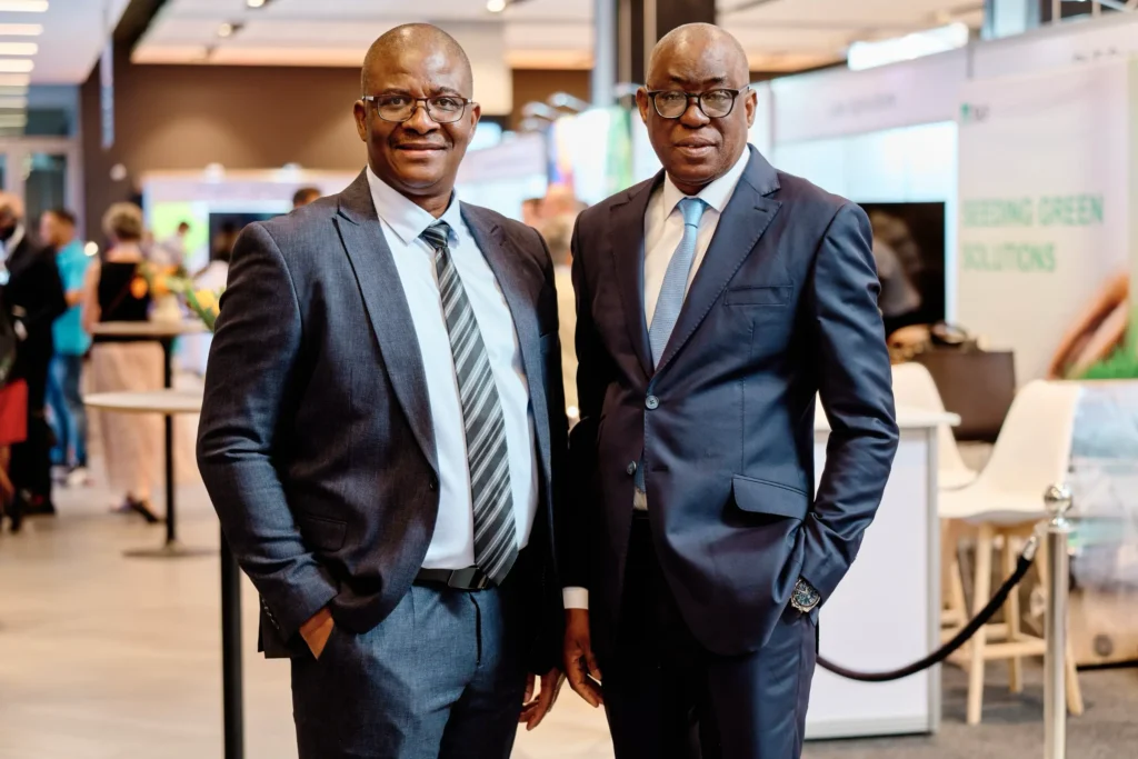 Two business executives posing together at the exhibition area of a corporate conference at the Century City Convention Centre in Cape Town.
