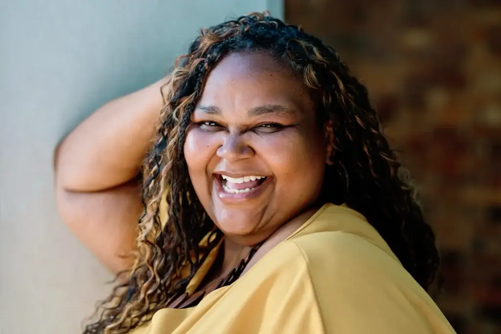Jenita Lawal laughing during her personal branding photography session in the Company's Garden, Cape Town