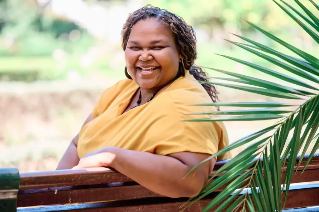 Jenita Lawal seated on a park bench in the Company's Garden during her personal branding session, Cape Town