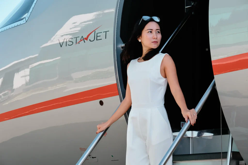Full-length portrait of the VistaJet Vice President for Marketing on the stairs of a private VistaJet aircraft, Cape Town