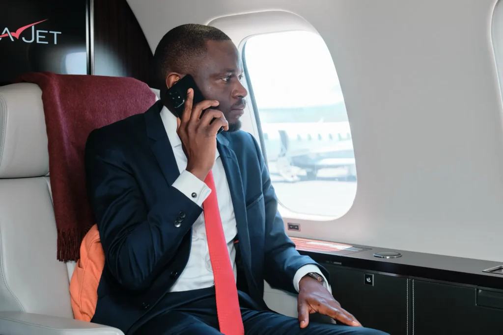 VistaJet executive seated inside the aircraft cabin, on a phone call