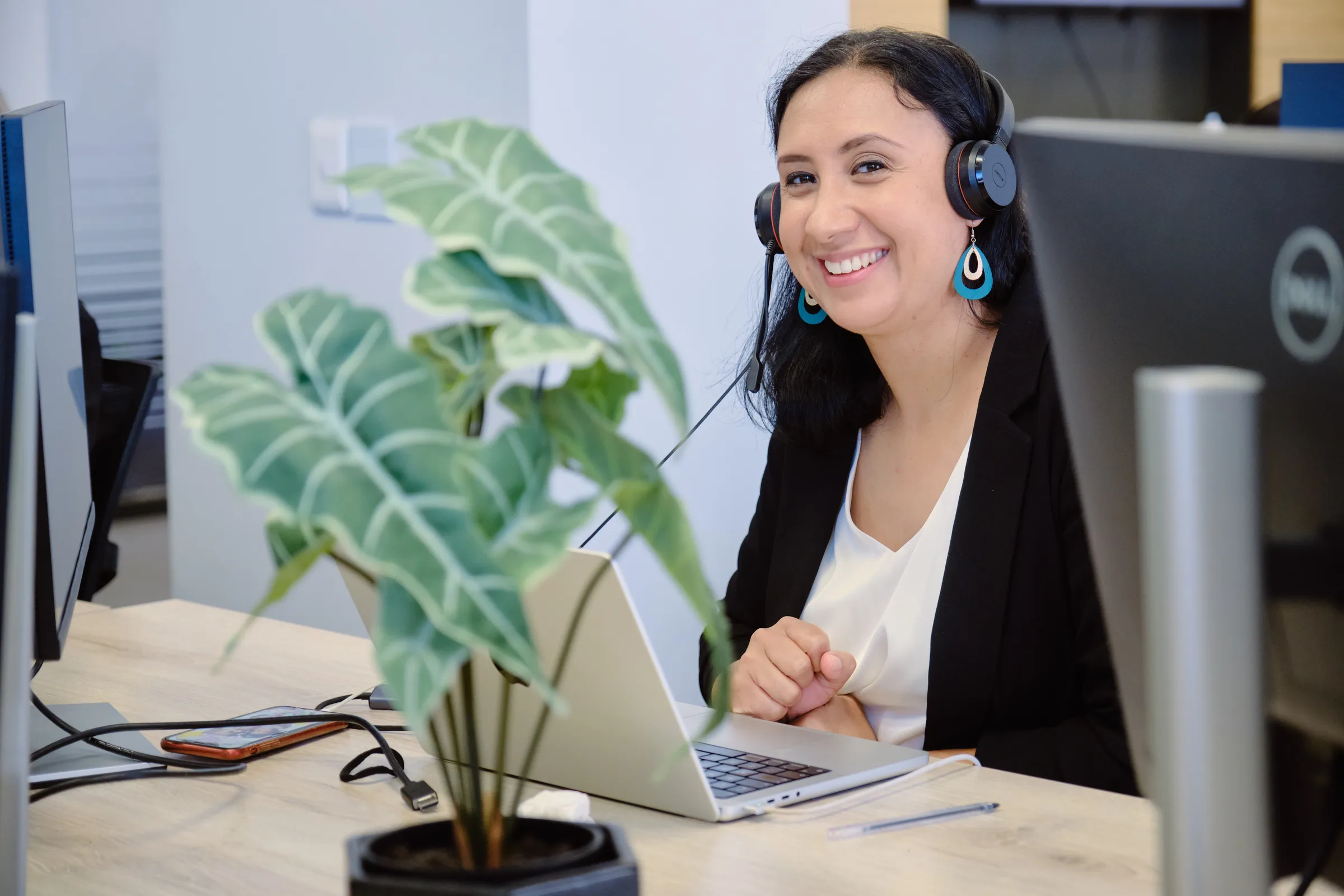 LevelUp HCS recruiter smiling at her desk wearing a headset, Cape Town office