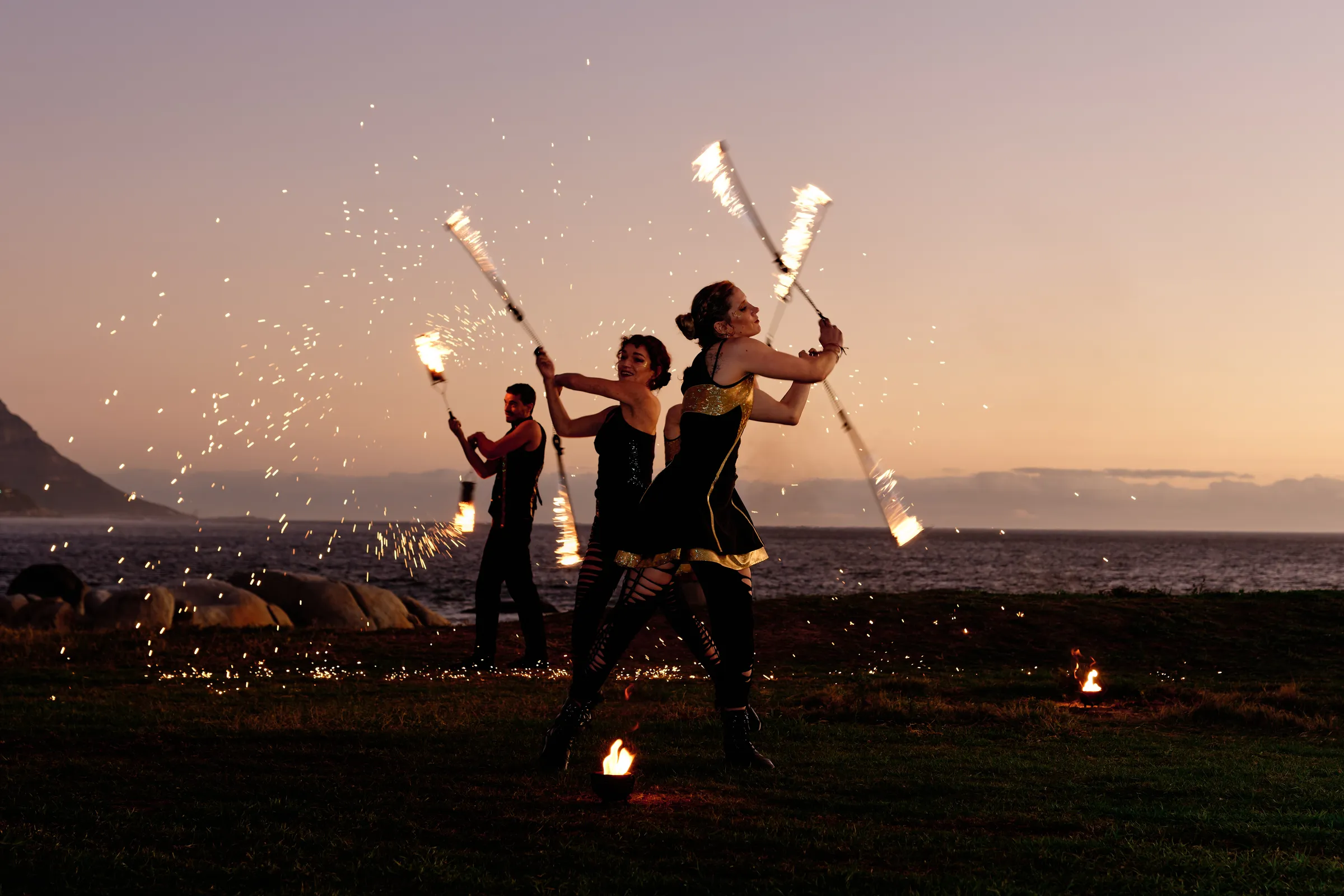 Fire performers at sunset on the Cape Town coast during an incentive programme