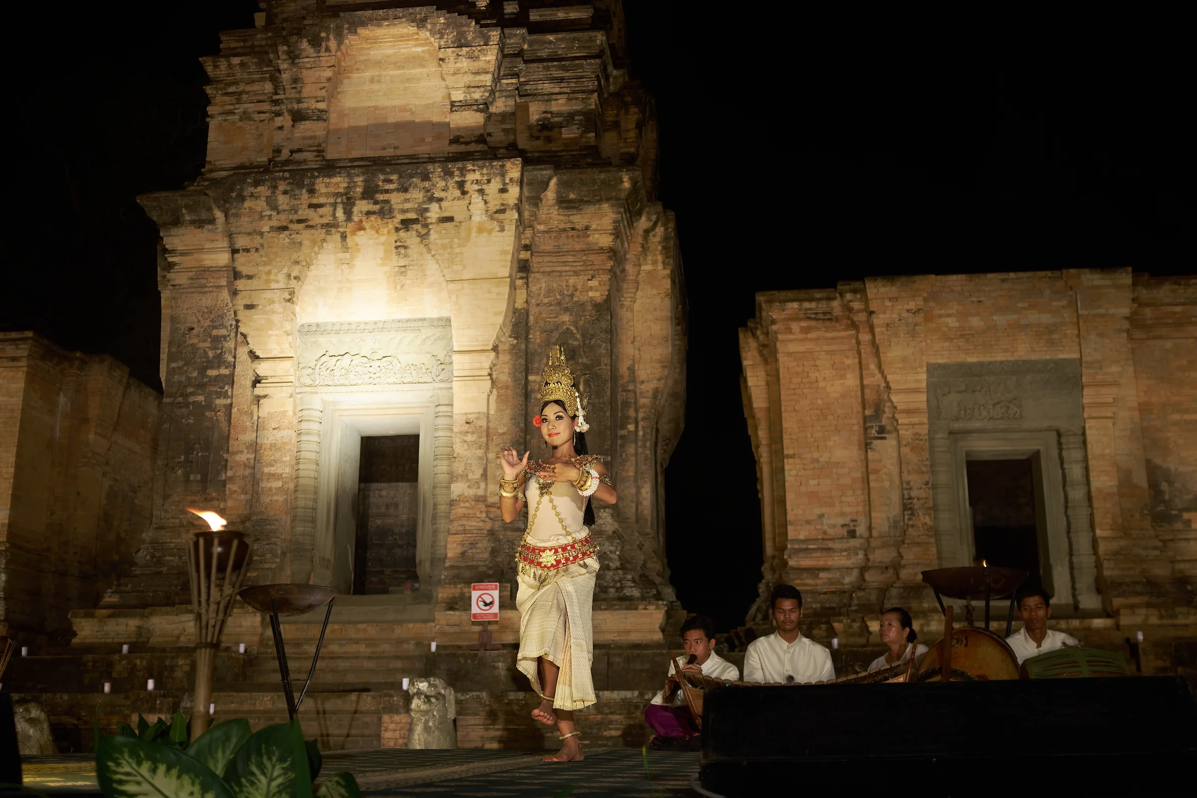 Apsara dancer performing in front of a floodlit temple at night, Angkor, Cambodia