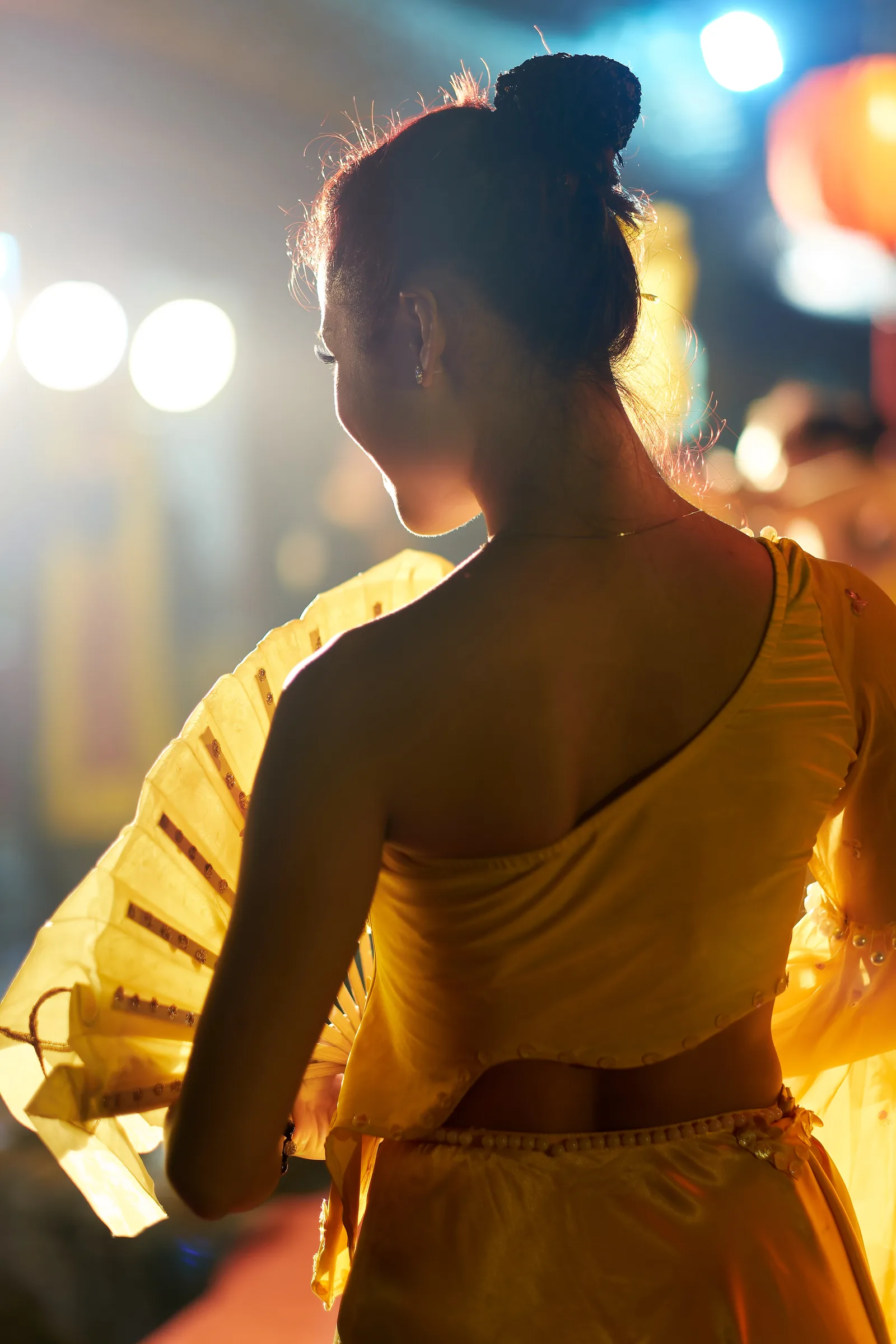 Dancer with a fan performing under lanterns at the Temple of Literature, Hanoi, Vietnam