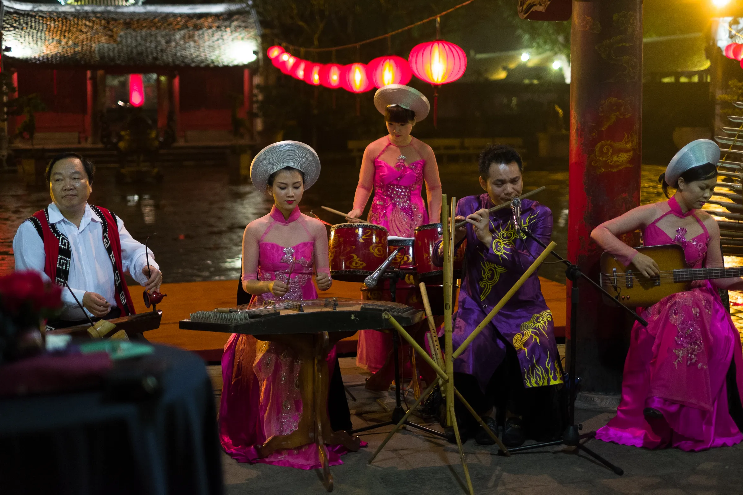 Traditional Vietnamese ensemble performing under lanterns at an evening reception, Hanoi