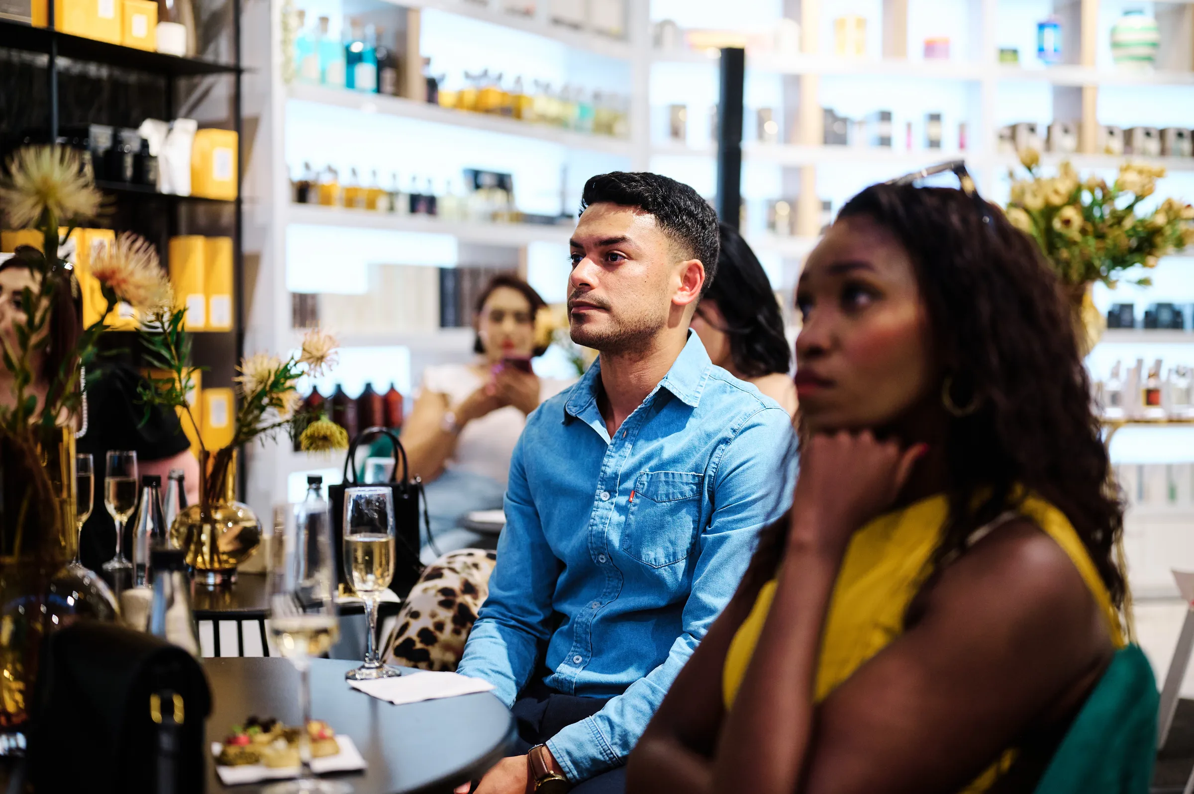 Guests seated among the store shelves ahead of the presentation at a retail fragrance launch, Cape Town