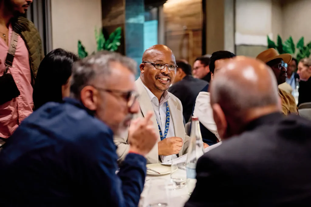 Candid corporate event photography showing natural networking interactions and authentic delegate connection at a business dinner.