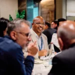 Candid corporate event photography showing natural networking interactions and authentic delegate connection at a business dinner.