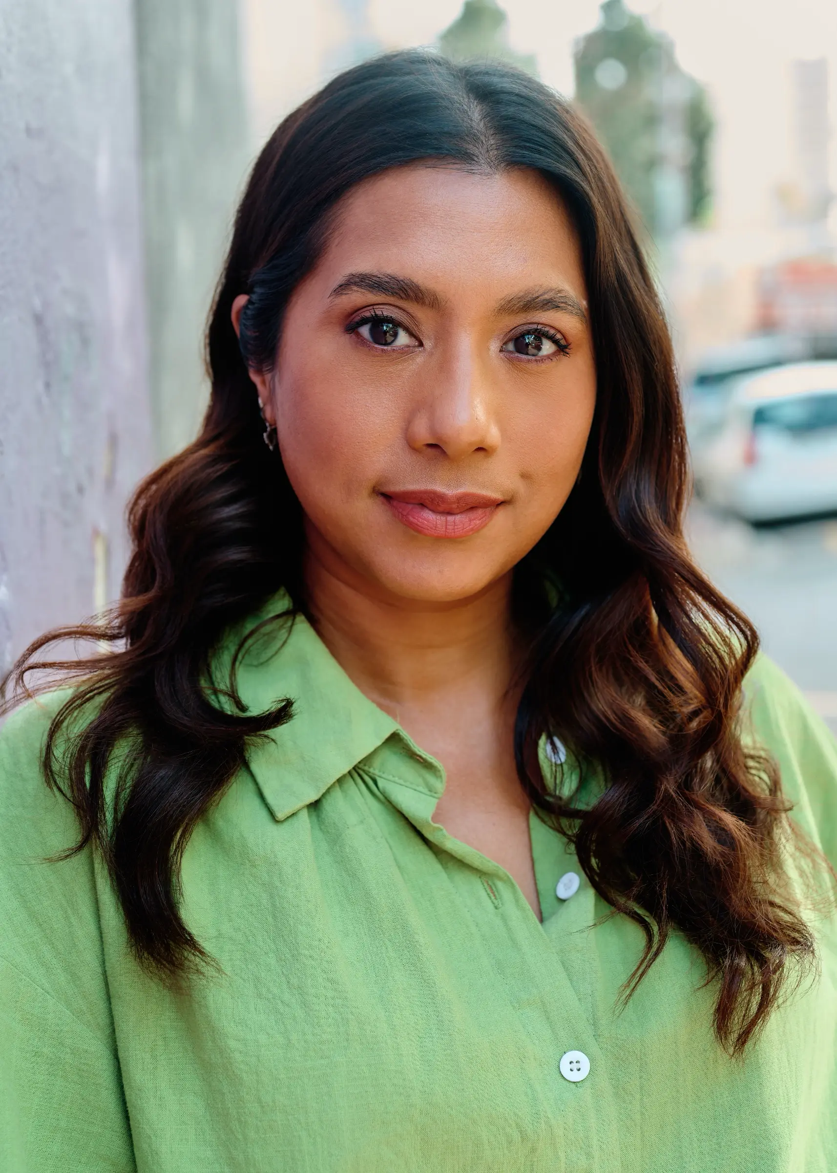 A clean, approachable environmental headshot captured in a soft, urban Cape Town setting.